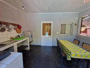 a kitchen and dining room with a table and chairs at Bungalow chez Mouch Nosy-Be 4 in Nosy Be