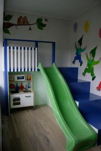 a childs bedroom with a green slide in a room at Ostfriesland Ferien Villa - 24 Personen - Sauna, Whirlpool , Kino, und Bar in Backemoor +17 photos
