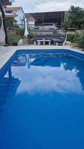 a swimming pool with blue water in a house at Bonvivan House in Diminići