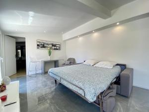 カンヌにあるLuxury "Les Toits du Soleil" - Magnifique appartement avec terrasses et jacuzzi - Centre de cannes - By SCLS Locationsのベッドルーム1室(ベッド1台付)、リビングルームが備わります。