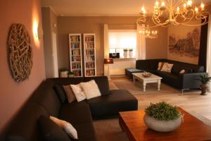 a living room with a couch and a table at Tolles Ferienhaus für 18 Personen in Ostfriesland mit Kino, Bar, Sauna und Whirlpool in Backemoor +15 photos
