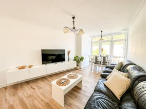 a living room with a couch and a tv at Apartamento Luar by ALÔGA in Cee