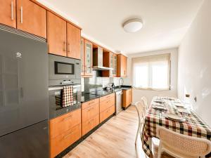 a kitchen with a table and a dining room at Apartamento Luar by ALÔGA in Cee