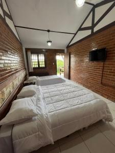 um quarto grande com 2 camas e uma parede de tijolos em Hotel Fazenda Ceu Aberto em Gravatá