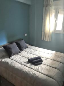 duże białe łóżko z dwoma czarnymi ręcznikami w obiekcie 3 bedrooms apartement with city view balcony and wifi at Malaga 1 km away from the beach w Maladze