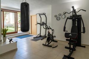 a gym with several tread machines and a punching bag at Appartamenti Le Vele in La Maddalena