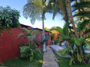 a red house with palm trees in front of it at Bungalow chez Mouch Nosy-Be 4 in Nosy Be
