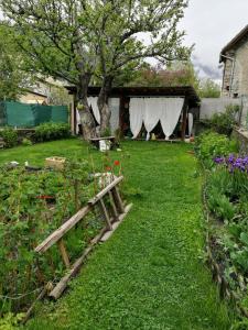 a garden with a wooden bench in the grass at studio ensoleillé avec jardin pour 2 à Monêtier in Le Monêtier-les-Bains