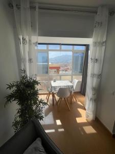ベナルマデナにあるLuminoso Estudio c magnificas vistas, Recp 24 hsのテーブルと大きな窓のあるリビングルーム