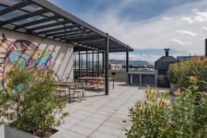 a patio with tables and chairs on top of a building at UMA Suites Chia in Chía
