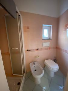 a bathroom with a toilet and a sink at Appartamento Calarossa Sardegna CasaRosa in Isola Rossa +22 photos