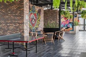 a ping pong table and chairs in front of a brick wall at UMA Suites Chia in Chía