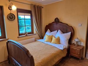 a bedroom with a bed with pillows and a window at Szachulcowa Zagroda in Ustka