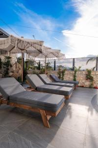 een rij ligstoelen met parasols op een patio bij Ori Mare Hotel in Ksamil