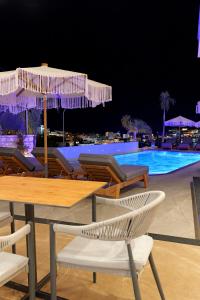 una mesa y sillas con sombrillas junto a la piscina en Ori Mare Hotel, en Ksamil