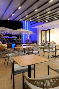 クサミルにあるOri Mare Hotelのテーブル、椅子、パラソルが備わるレストラン