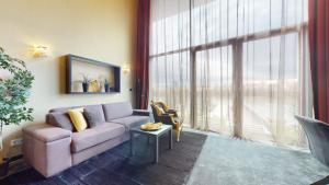 uma sala de estar com um sofá e uma grande janela em Eurovea Apartments em Bratislava