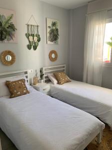 two beds in a room with white walls at APARTAMENTO DE LUJO EN LA VERA PLAYa GARRUCHA in Vera