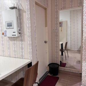a room with a kitchen with a table and chairs at Ground Floor Indah UUC Homestay KKIP Kota Kinabalu in Kota Kinabalu