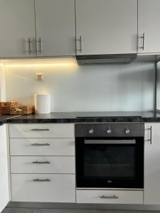 a kitchen with white cabinets and a black oven at Flats 5-11 apts in Heraklio +6 photos
