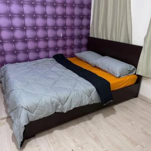 a bed with a purple headboard in a bedroom at Ground Floor Indah UUC Homestay KKIP Kota Kinabalu in Kota Kinabalu