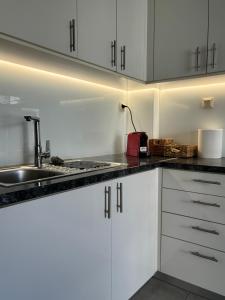 a kitchen with white cabinets and a sink at Flats 5-11 apts in Heraklio