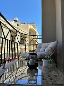 a balcony with a couch and a glass table at Flats 5-11 apts in Heraklio