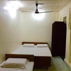 a room with two beds and a dresser in it at GRG Shanti Guest House Varanasi Near Manikarnika Ghat in Varanasi