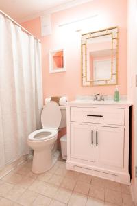 a bathroom with a toilet and a sink and a mirror at Beach-Pool-Private Balcony in Tybee Island