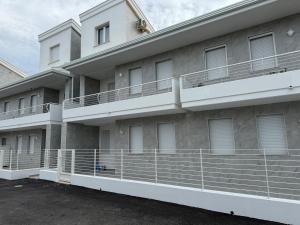 un edificio de apartamentos con balcones blancos y aparcamiento en Residence Riva del Mulino, en Marina di Montenero