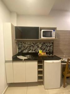 a small kitchen with a sink and a microwave at Studio Luxury Copa - beira mar in Rio de Janeiro +16 photos