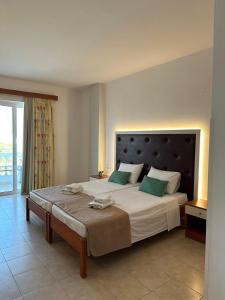 a bedroom with a large bed with green pillows at Apollonio Suites & Rooms Faliraki Rhodes in Faliraki