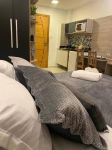 1 dormitorio con 2 camas con almohadas y cocina en Studio Luxury Copa - beira mar, en Río de Janeiro