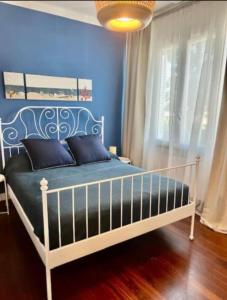a bedroom with a bed with a blue wall at Casa Marchese in Tirrenia
