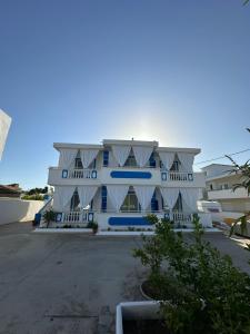 een groot wit gebouw met blauwe ramen bij Apollonio Suites & Rooms Faliraki Rhodes in Faliraki