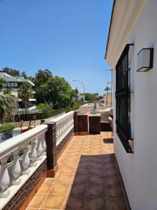 Un balcón de una casa con una valla y una ventana en Pedregalejo Beach House, en Málaga