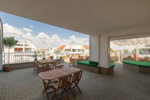 eine Terrasse mit Tischen und Stühlen auf dem Balkon in der Unterkunft Rooftop City Residence in Budapest