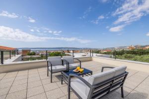 eine Terrasse mit zwei Stühlen und einem Tisch auf einem Balkon in der Unterkunft Villa Teuta in Kaštel Stari