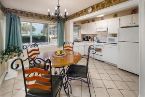 een keuken met een tafel en stoelen en een keuken met witte kasten bij Seaspray Condos 210B in Fort Walton Beach