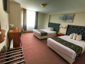 Habitación de hotel con 2 camas y TV en Casona Plaza Hotel Puno en Puno
