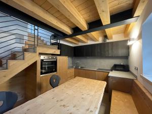 uma cozinha com uma mesa de madeira e uma escada em Chalet Le Grazie em Le Grazie