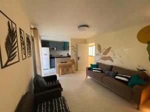 a living room with a couch and a kitchen at Paraíso in Cumbuco