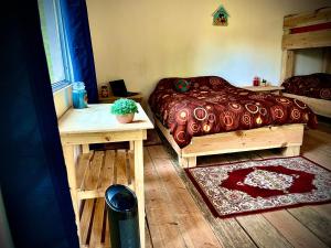 een slaapkamer met een bed en een tafel met een potplant bij Casa De Campo in Acaxochitlán