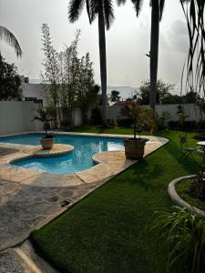 a swimming pool in a yard with palm trees at VILLAS EL ENCANTO in Jalpan