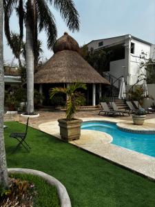 een resort met een zwembad met een rieten parasol bij VILLAS EL ENCANTO in Jalpan