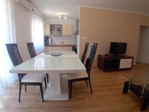 y cocina con mesa de comedor blanca y sillas. en Apartments Angie, en Zadar