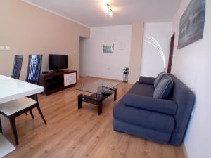 sala de estar con sofá azul y mesa en Apartments Angie, en Zadar