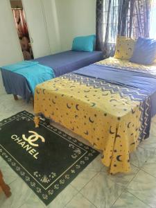 2 Betten nebeneinander in einem Zimmer in der Unterkunft Fay Guest House in Negril