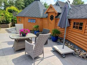 a patio with a table and chairs and an umbrella at Finse Kota met privé Sauna en Hottub in Spanbroek