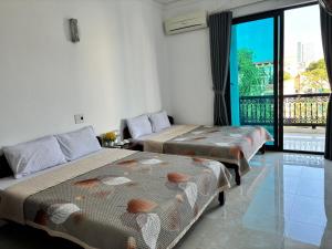 2 camas en una habitación con ventana grande en Khách Sạn Tuấn Thảo Cửa Lò en Cửa Lò